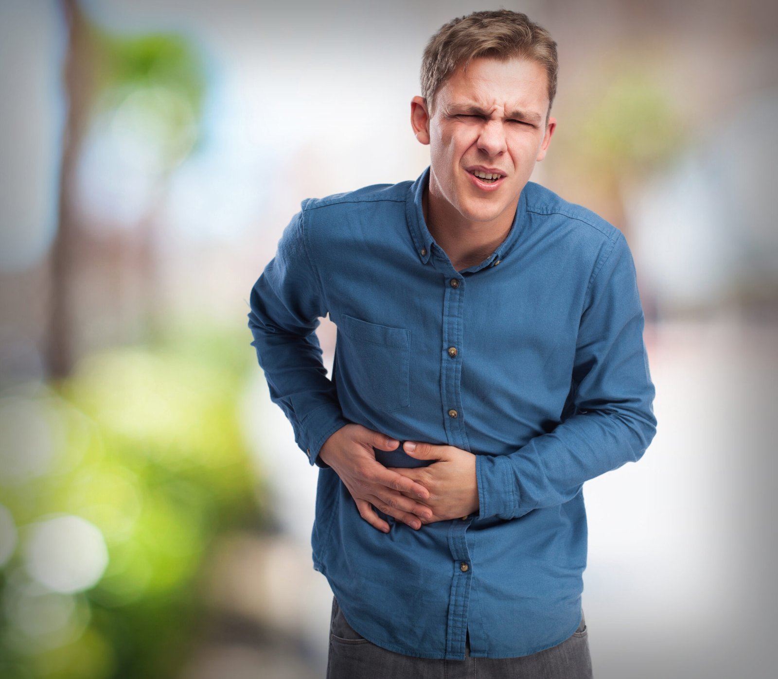 Young man experiencing abdominal pain, possible GERD or digestive disorder
